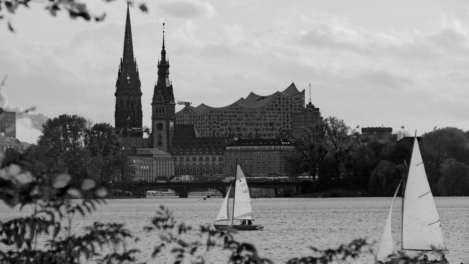 Blick über die Außenalster auf die Innenstadt mit Rathaus, im Vordergrund Segelboote